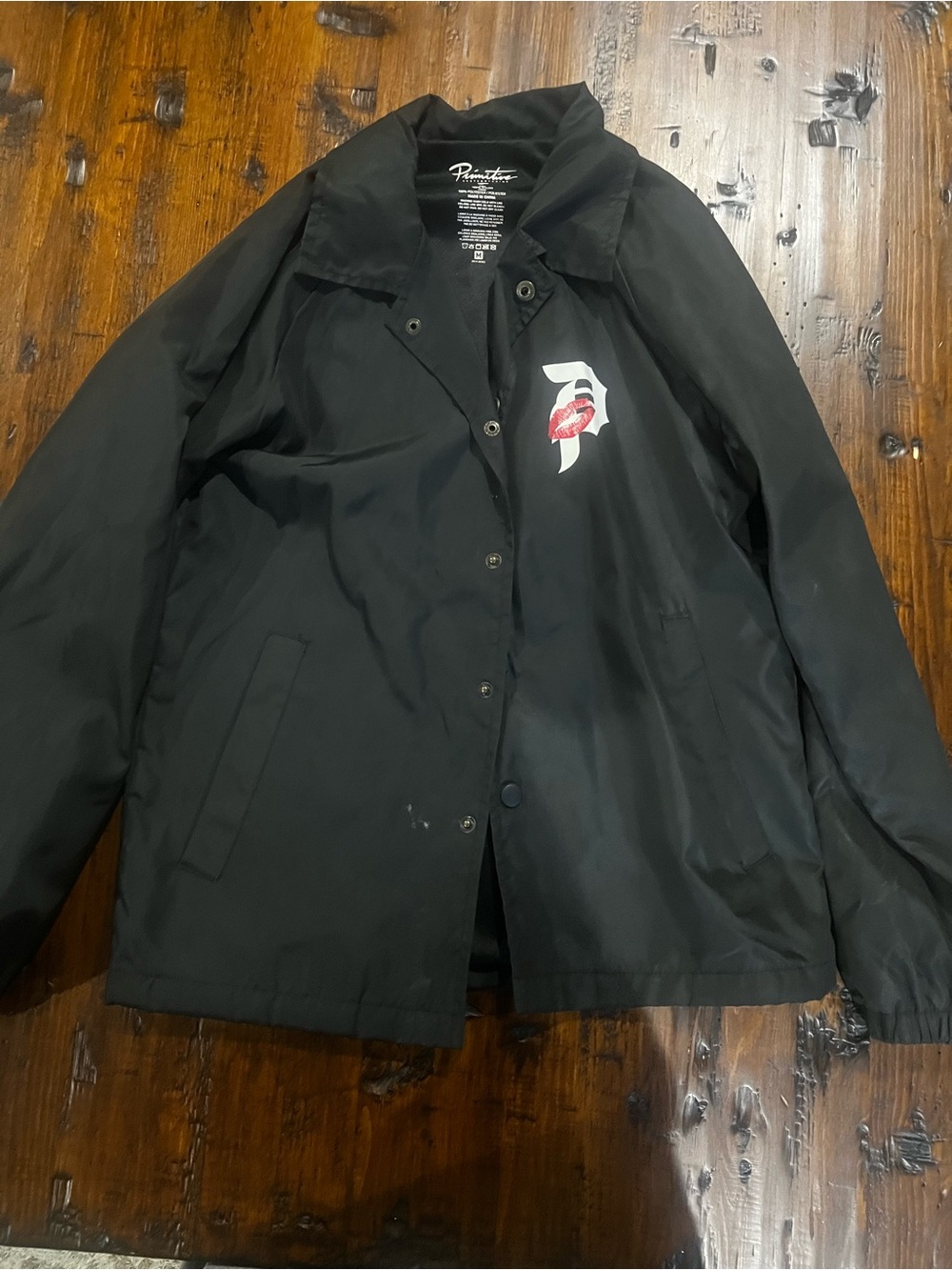 Primitive Black Coach Jacket with White and Red Lip Graphic